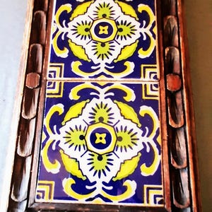 Mexican carved wooden frame and Mexican tiles make this a nice Trivet, coffee holder.  measures7 inches wide, 11 inches long.