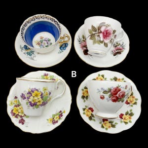 May include: Four vintage teacups and saucers are displayed against a black background. The teacups feature floral designs and gold trim. One cup has a blue interior, while others showcase pink, red, and yellow roses and other flowers.