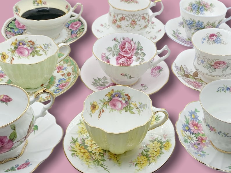 May include: A collection of vintage teacups and saucers. The cups and saucers feature floral patterns in various colors, including pink, yellow, blue, and green, with gold trim. The teacups are arranged on a pink background.