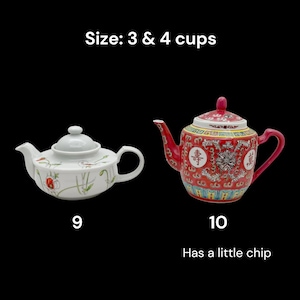 May include: Two teapots on a black background. One is white with floral designs, the other is red with ornate patterns. Text indicates sizes of 3 and 4 cups. One teapot has a small chip.