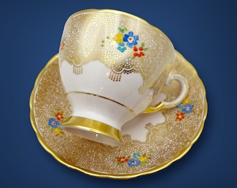 Taza y platillo de porcelana fina toscana vintage: diseño floral rosa y dorado.
