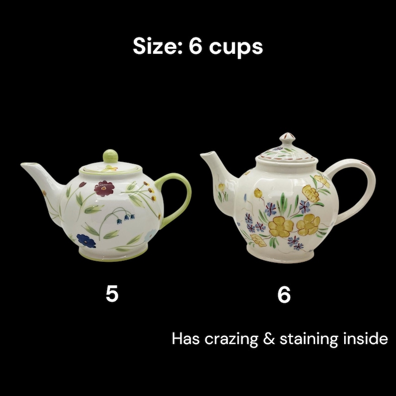May include: Two white ceramic teapots with floral designs. One teapot has a green handle and lid, the other has a white handle and lid. The text "Size: 6 cups" is above the teapots. The text "Has crazing & staining inside" is below the teapots.