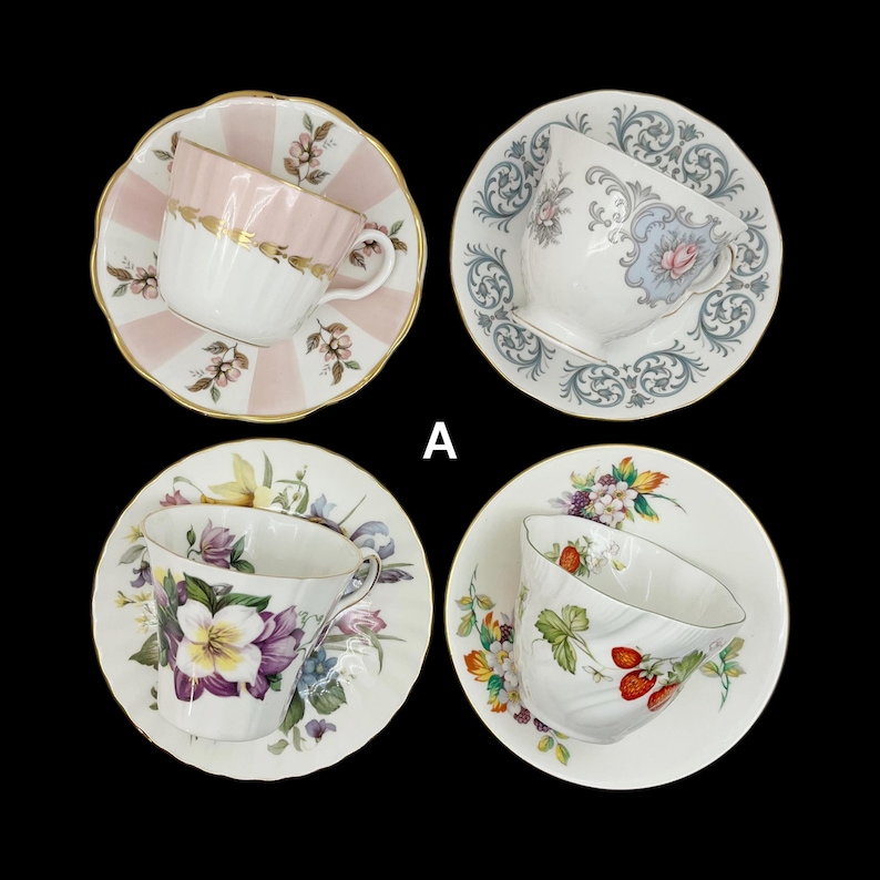 May include: Four vintage teacups and saucers are displayed against a black background. Each cup features a unique floral design and color scheme, including pink, blue, purple, and red. The saucers have scalloped edges and complement the cups' patterns.