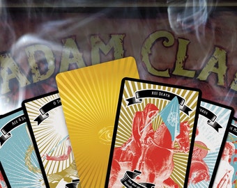 May include: A set of tarot cards with colorful illustrations and gold accents. The cards feature the Ace of Swords, the 10 of Swords, Death, and the World. The cards are laid out on a wooden surface with the text "ADAM CLA" visible in the background.