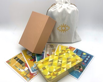 May include: A set of tarot cards with colorful illustrations and a beige box. The cards are spread out on a white surface. The box has a simple design and is made of cardboard. The cards are a popular tool for divination and self-discovery.