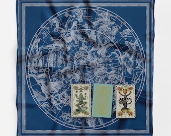 May include: A blue silk scarf with a white star chart design and three tarot cards. The cards are "The Fool", "The World", and "Justice".