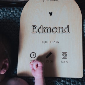 Może przedstawiać: Drewniany znak z imieniem Edmond, datą 11 lipca 2024 i ikonami czasu, długości i wagi. Znak jest jasnobrązowy i ma kształt serca u góry.