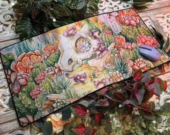 May include: A colorful mousepad featuring a skull with flowers and plants. The skull is surrounded by a variety of green plants and flowers, including cacti and succulents. A purple computer mouse is on the mousepad.