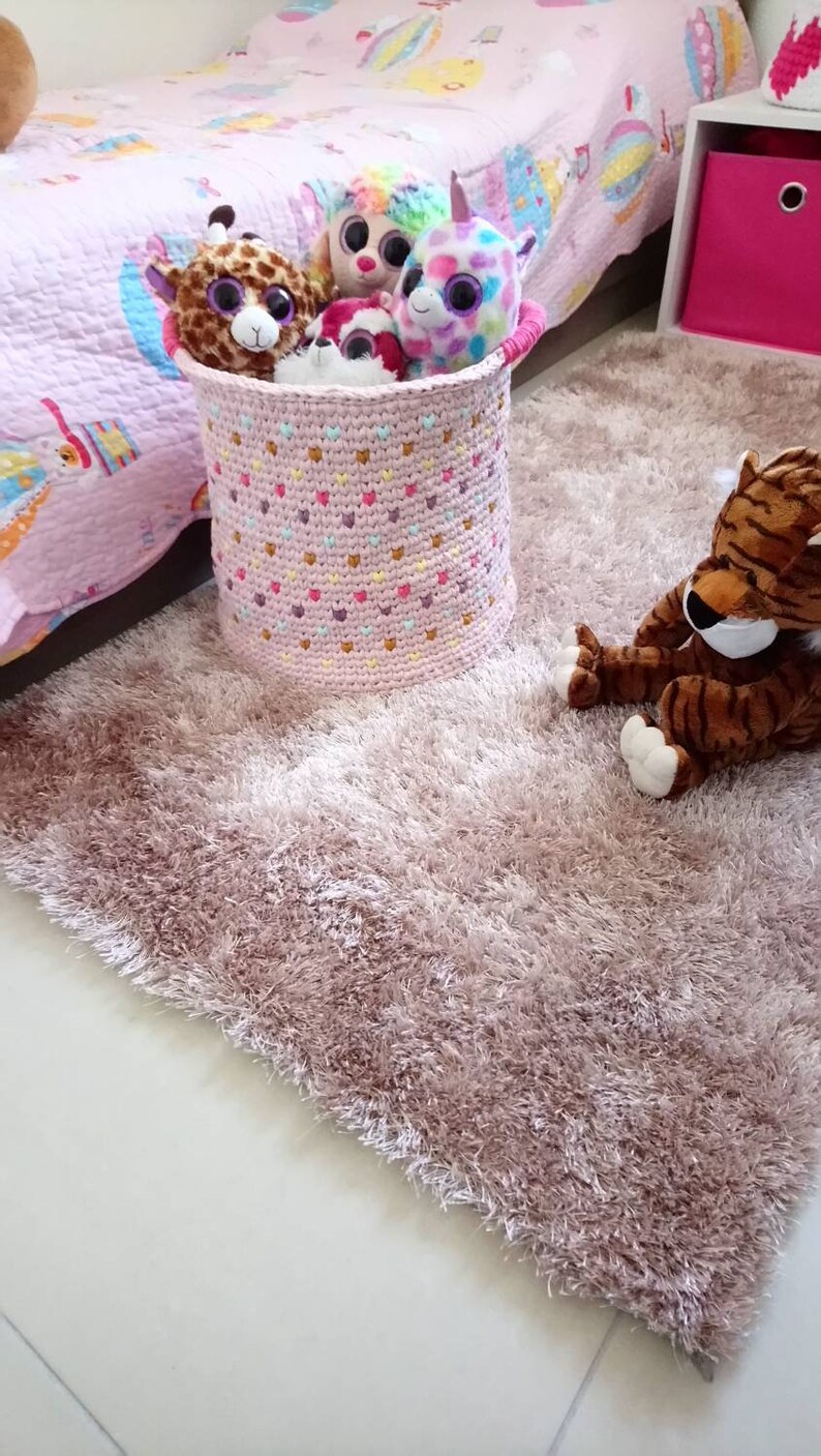 Large basket of multicolored crochet toy storage for baby or little girl