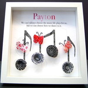 May include: A white framed picture with the name "Payton" at the top. The picture features a quote about music and life, and is decorated with paper butterflies and musical notes.