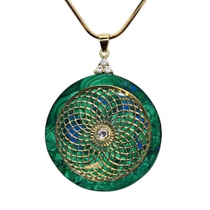 May include: A gold chain necklace with a round green and blue malachite pendant featuring a gold filigree design and a clear crystal in the center.