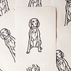 May include: A collection of white cards featuring a black line drawing of a dog in a seated position. The dog has a collar and is depicted with simple, bold lines. The cards are scattered, with some partially visible.