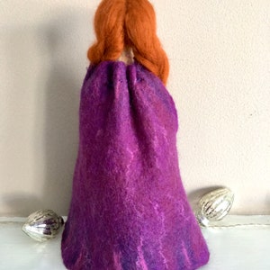 May include: A felt doll with long, braided, auburn hair wearing a purple, hand-felted cloak.