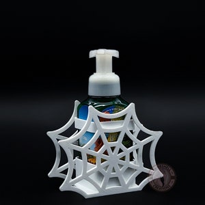 May include: White 3D printed spiderweb soap dispenser holder. The holder is designed to fit a standard size foaming soap bottle. The holder is a great way to add a spooky touch to your bathroom decor.
