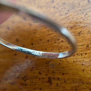 Puede incluir: Primer plano del interior de un anillo de plata con la inscripci&oacute;n "14K KULL" grabada en la banda.