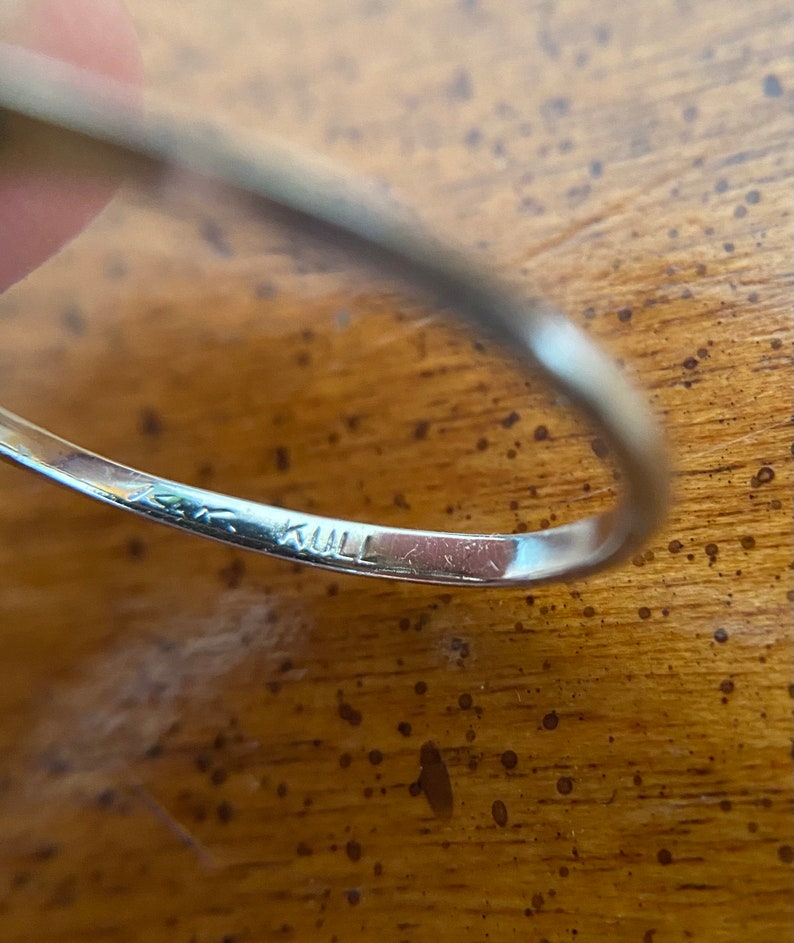 Puede incluir: Primer plano del interior de un anillo de plata con la inscripci&oacute;n "14K KULL" grabada en la banda.