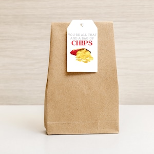 May include: A brown paper gift bag with a white gift tag that says "You're all that and a bag of chips" with a cartoon image of a bag of chips.