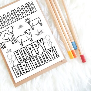 K&ouml;nnte beinhalten: Schwarz-wei&szlig;e Geburtstagskarte mit Bauernhoftieren und dem Text "HAPPY BIRTHDAY!". Vier Bleistifte mit farbigen Spitzen und dem Text "BOSS LADY" liegen neben der Karte. Die Karte befindet sich in einem braunen Umschlag.