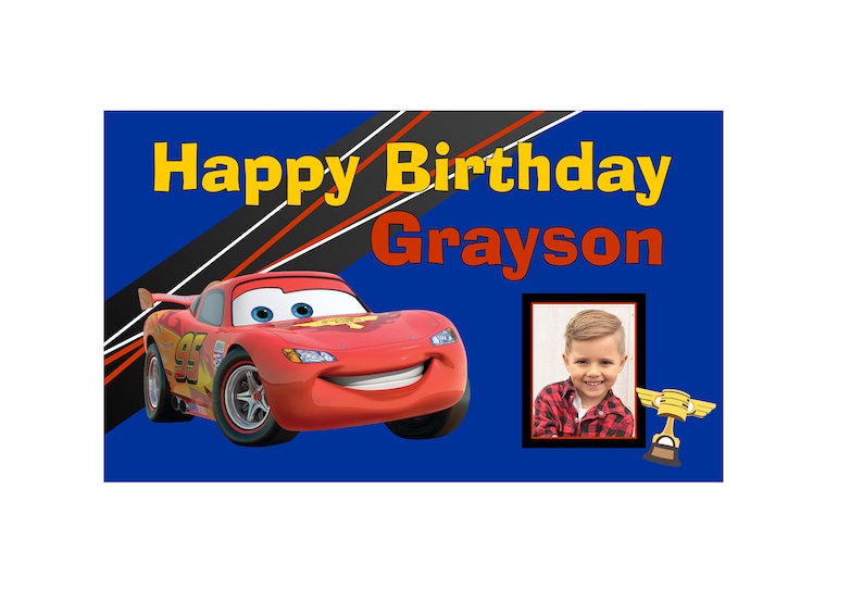 May include: A blue banner with the text "Happy Birthday Grayson" in yellow and red letters. A red cartoon race car is on the left side of the banner. A photo of a young boy is on the right side of the banner.