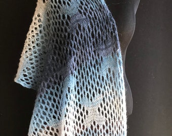 Könnte beinhalten: Ein blauer, weißer und grauer gestrickter Schal mit einem Spitzenmuster. Der Schal ist über eine Schaufensterpuppe gelegt.