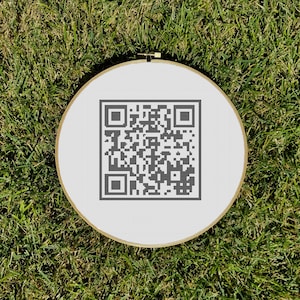 May include: A white embroidery hoop with a black and white QR code design.