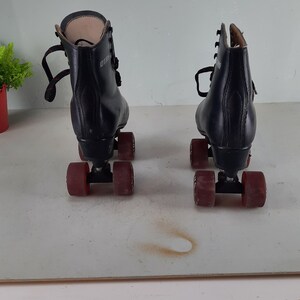 May include: A pair of black roller skates with red wheels. The skates have laces and are in good condition.