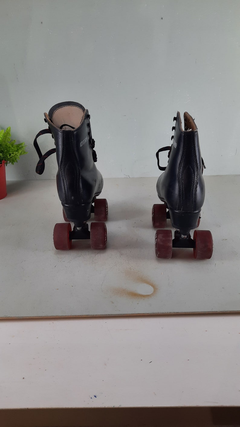 May include: A pair of black roller skates with red wheels. The skates have laces and are in good condition.