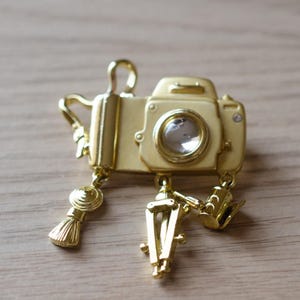 Signed Danecraft gold-tone Camera brooch with dangling Film Tripod Brush Charms