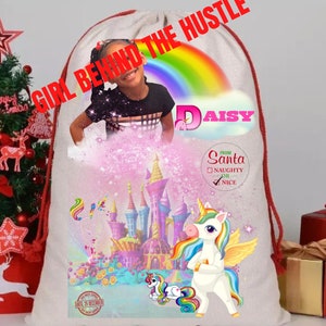 May include: A white Christmas stocking featuring a rainbow and unicorn design. The stocking is personalised with the name "Daisy" and a message from Santa. The stocking has a red drawstring and red trim.