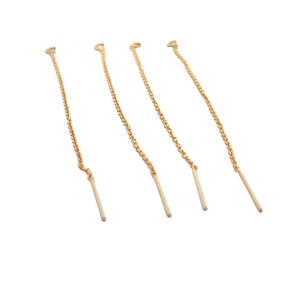 May include: Four gold chain earring extenders with a straight, thin, gold bar at the end.