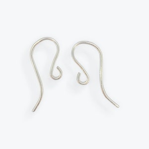 May include: Two silver earring hooks, each with a curved wire and a small loop at the top.