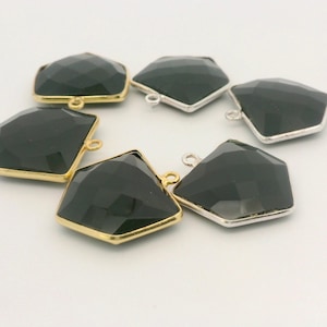 May include: Six black faceted gemstone pendants with gold and silver-colored metal frames. Each pendant has a loop for attaching to a chain or other jewelry component. The gemstones are cut in a geometric shape.