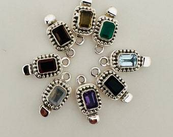 May include: Eight silver charm pendants with different colored gemstones. Each pendant features a rectangular gemstone set in a silver frame with a beaded border. The gemstones are amethyst, aquamarine, black onyx, smoky quartz, garnet, green aventurine, labradorite, and citrine.