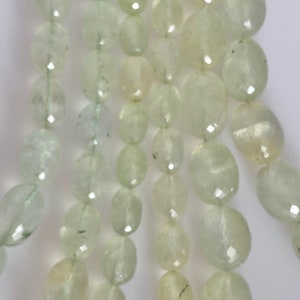 May include: A strand of light green oval-shaped beads. The beads are translucent and have a slightly frosted appearance.