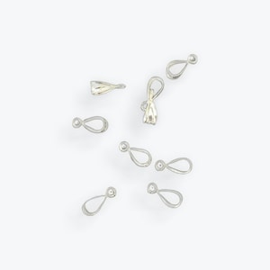 May include: A collection of silver-toned metal pendant bails, some with a loop at the top and others with a flat top. These bails are used for attaching pendants to necklaces or bracelets.