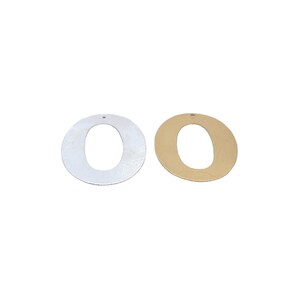 May include: Two metal letter O charms, one silver and one gold. Both charms have a hole at the top for hanging.