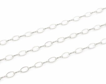 Puede incluir: Una cadena de metal plateado que presenta una serie de eslabones ovalados alargados y uniformes conectados en un patrón continuo y repetitivo. La cadena se muestra en tres segmentos paralelos ligeramente curvados sobre un fondo blanco.