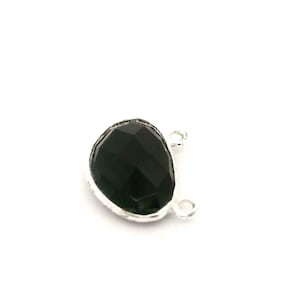 Puede incluir: Un colgante de piedra preciosa negra facetada con un bisel plateado y dos pequeños bucles para sujetarlo a una cadena u otro componente de joyería. La piedra preciosa tiene forma de lágrima.