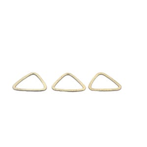 May include: Three gold triangle shaped metal charms. The charms are smooth and have a slightly textured surface.