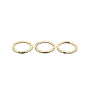 Puede incluir: Tres anillos de metal de color dorado con textura martillada.