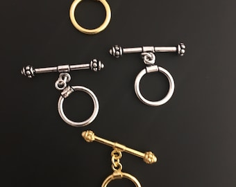 A Pack of 5 or 6 pieces of Decorated Toggles, E-Coated, Designer's Toggles, Available in 2 sizes  & 2 Colors Gold finish and Silver Plated.