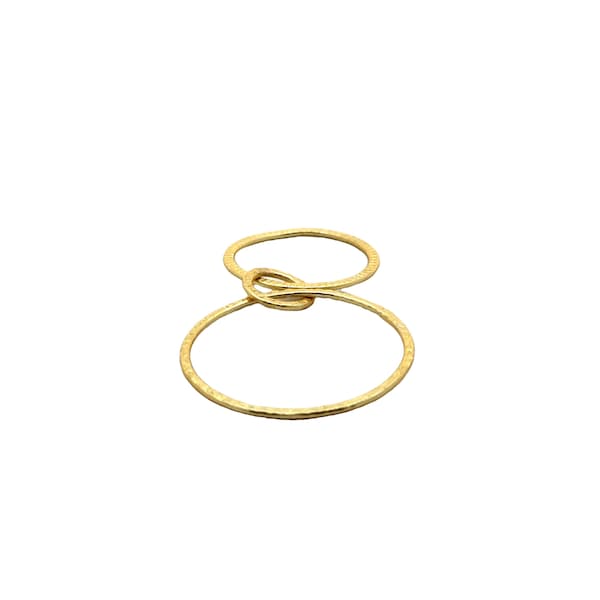 Op de afbeelding: Gouden ring met twee in elkaar grijpende cirkels, een kleinere en een grotere, met een getextureerde afwerking.