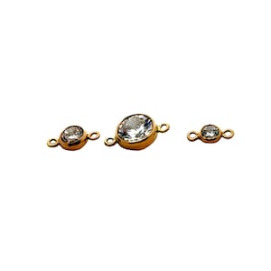 May include: Three gold-toned connector pieces with clear crystal accents. The connector pieces are designed to be used in jewelry making.