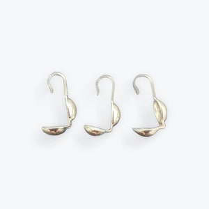 May include: Three silver-toned metal earring hooks with a rounded end. The hooks are designed to be used with a bead or charm.