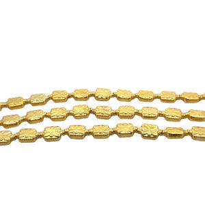May include: Gold chain with square links, each link has a decorative design. The chain is shown in three rows.
