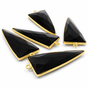 May include: Five triangular black onyx pendants with faceted surfaces, each encased in a polished gold-tone metal frame. Every pendant features a small circular jump ring attached to one of the corners for hanging, showcasing a smooth finish.