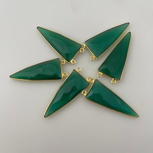 May include: Six green gemstone triangle pendants with gold-toned jump rings. The pendants are arranged in a star shape.