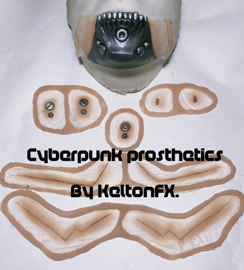 May include: A set of cyberpunk prosthetic makeup pieces for a costume or special effects project. The set includes a mouth piece, two cheek pieces, two eyebrow pieces, and two pieces for the neck. The pieces are made of a flexible material and are designed to be applied to the skin.