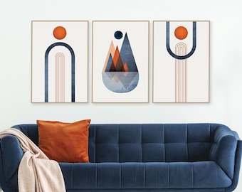 May include: Three abstract art prints with geometric shapes in shades of orange, blue, and brown. The prints are framed in wood and hung on a white wall above a blue velvet sofa.