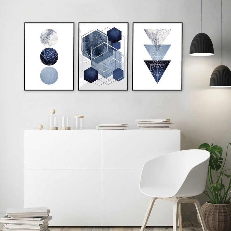 May include: Three abstract geometric wall art prints in shades of blue and gray. The prints feature a circle, a hexagon, and a triangle.